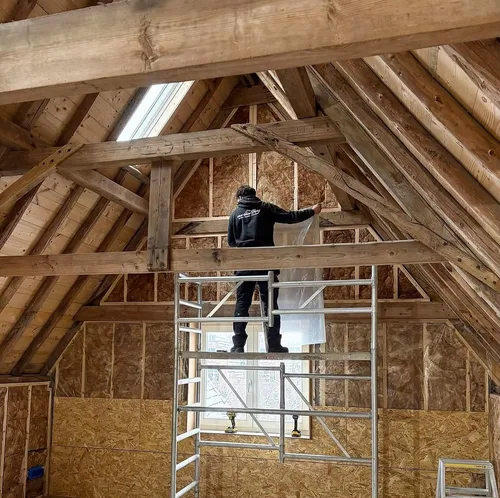 Vakman aan het werk tussen de kapconstructie